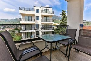 a balcony with a table and chairs and a building at Lux Apartmani Djukic in Bar +34 photos