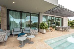 a patio with chairs and a table and a pool at Coastal villa w dock access & pools u401 in Barú