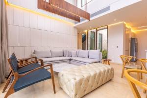 a living room with a white couch and chairs at Coastal villa w dock access & pools u401 in Barú +60 photos