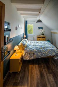 a bedroom with a bed and a table with a lamp at Le nid du Curtil - Chambre d'hôtes in Rougegoutte