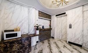a kitchen with marble walls and a microwave on a counter at Hasen Hotel in Siheung