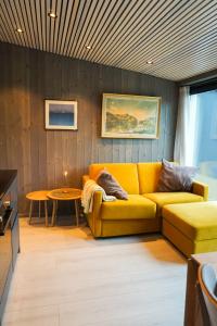 a living room with a yellow couch and a table at Modern One-Bedroom Apartment in Henningsvær in Henningsvær