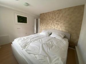a bed with white sheets and pillows in a bedroom at Ferienwohnung Habichtsnest in Runkel
