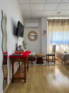 a living room with a table and a tv on a wall at Hotel Argos in Calasparra