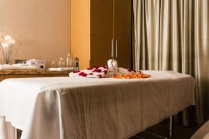 a bed with a white table with flowers on it at Royal Canaan Nairobi Hotel in Nairobi