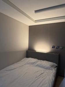 a bedroom with a white bed with a light above it at Yangyang Surfing Beach 18 in Saetchak