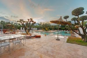 a patio with tables and chairs and a swimming pool at Ksar Shama - Atlas Mountain Retreat in Ouirgane