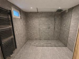 a bathroom with a shower with a tiled floor at Pulheim Room in Pulheim