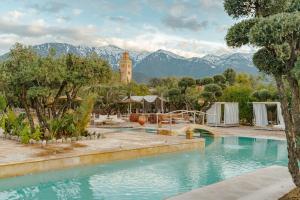 a resort with a swimming pool with mountains in the background at Ksar Shama - Atlas Mountain Retreat in Ouirgane