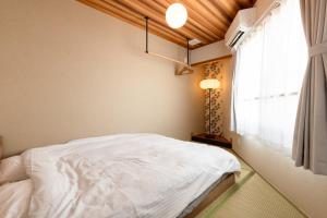 a bedroom with a white bed and a window at 翡翠名古屋本陣 in Nagoya