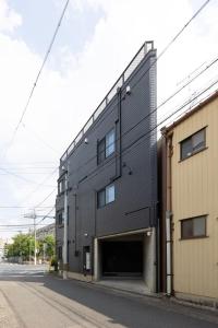 a black building with a garage on the side of a street at 翡翠名古屋本陣 in Nagoya