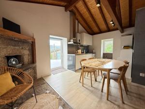 a kitchen and dining room with a table and chairs at Casa do Oliveira - Gerês in Terras de Bouro