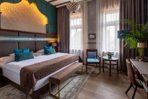 ein Hotelzimmer mit einem großen Bett und einem Tisch in der Unterkunft Hotel Golden Eagle in Levice