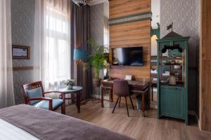ein Schlafzimmer mit Schreibtisch und ein Zimmer mit Bett in der Unterkunft Hotel Golden Eagle in Levice + 72 Fotos