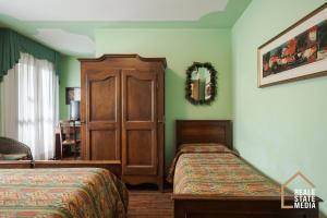 a bedroom with two beds and a wooden cabinet at Principato Di Ariis Hotel 3 stelle Room Only in Rivignano +108 photos