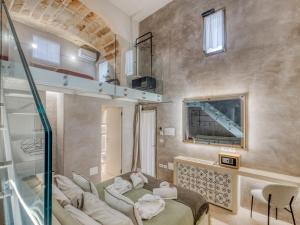 a bedroom with a bed and a couch and a mirror at SuiteCota24 piscina e spa in Lecce