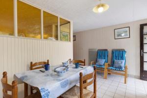 a dining room with a table and two blue chairs at Gîte 4 Pers L'étoile De Mer in Apremont