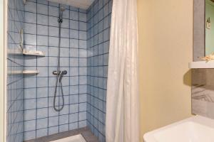 a blue tiled bathroom with a shower and a toilet at Gîte 4 Pers L'étoile De Mer in Apremont +25 photos