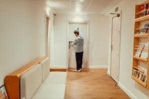 a man standing in a hallway looking at a door at Som Nit Port Vell in Barcelona +74 photos