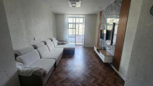 a living room with a couch and a television at Guest House 14th in Ulaanbaatar