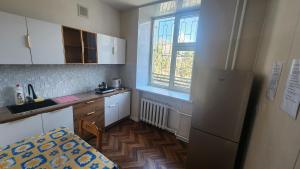 a small kitchen with a refrigerator and a window at Guest House 14th in Ulaanbaatar
