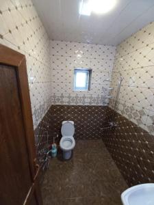 a small bathroom with a toilet and a window at Naz in Lerik +9 photos