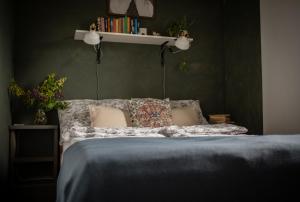 a bedroom with a bed with pillows and a shelf at TÉGED VÁRTALaK in Dörgicse