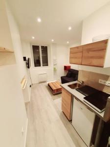 a kitchen with wooden cabinets and a counter top at Studio 2personnes entrée autonome in La Tronche