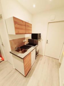 a small kitchen with a sink and a stove at Studio 2personnes entrée autonome in La Tronche