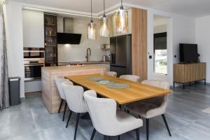 a kitchen and dining room with a wooden table and chairs at Villa Bartula in Bar