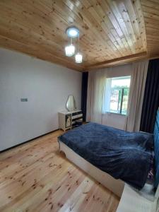 a bedroom with a bed and a wooden ceiling at Naz in Lerik