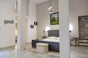 a bedroom with a bed and a stool in it at Bellosguardo Suites in San Paolo Bel Sito