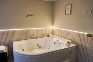 a bath tub in a bathroom with a sign on the wall at Bellosguardo Suites in San Paolo Bel Sito