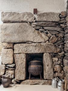 a stone fireplace with a pot in it at Casa do Caneiro in Vila Real