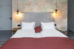 a large bed with white sheets and a red blanket at Villa Bartula in Bar