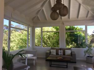 a living room with windows and a couch at La Posada Hotel in Pinamar