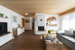 a living room with a couch and a fireplace at Chalet Stadel in Unterwasser