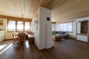 a dining room and living room with a table at Chalet Stadel in Unterwasser