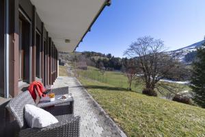 a person sitting on a bench on the side of a house at Chalet Stadel in Unterwasser