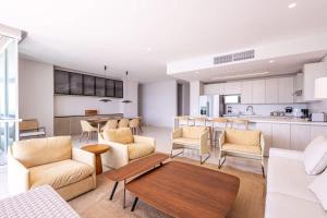 a living room with a couch and chairs and a kitchen at Oceanview 3br condo w spa & gym u603 in Barú