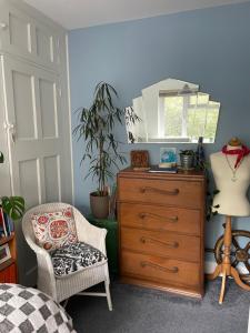 a bedroom with a dresser and a mirror and a chair at Bedroom 2 with a little loo in King's Lynn