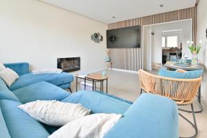 a living room with blue couches and a dining room at Le pacifique in Schiltigheim +11 photos