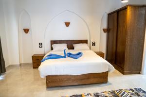 a bedroom with a bed with a blue robe on it at Azure Guest House in Luxor