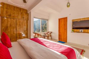 a bedroom with a large bed with a tv on the wall at Vamitag Inn in Shimla