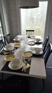 a table with plates and wine glasses on it at Villa Länsihuippu Incl WiFi, Pool table, AC, Jacuzzi for extra fee in Himos