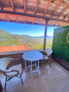 a table and chairs on a balcony with a view at kastro konak in Gokceada Town
