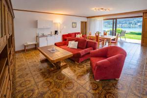 a living room with a red couch and a table at Haus Kapeller in Seeboden