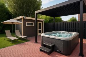 a hot tub in a backyard with a shed at Pulheim Room in Pulheim