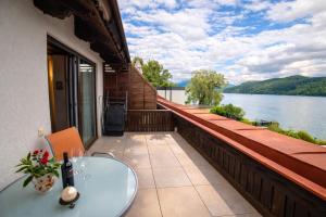 a balcony with a table and a view of a lake at Haus Kapeller in Seeboden