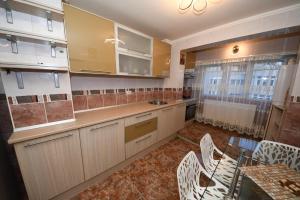 a kitchen with white cabinets and a table and chairs at Ket Apartments in Galaţi